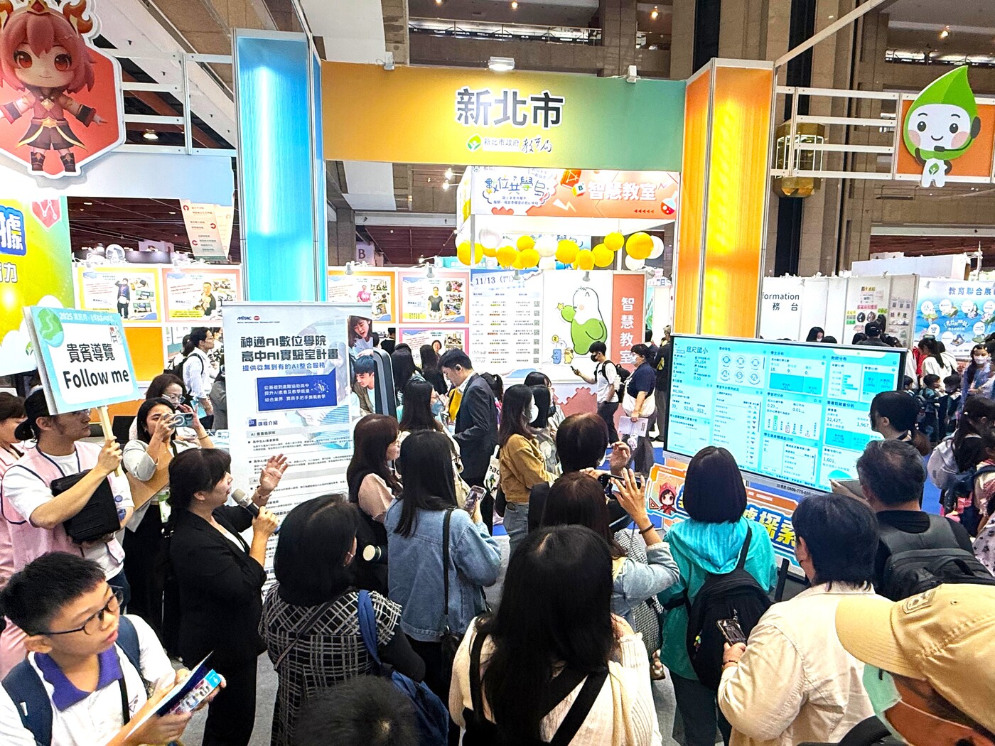 新北市數位學習辦公室主任何春緣於教育科技展現場，向苗栗縣數位學習辦公室團隊介紹。